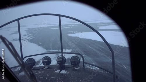 First-person view inside Hivus hovercraft racing over frozen Lake Baikal during blizzard. Extreme winter adventure, tourist cabin perspective showing ice and mountains through windows