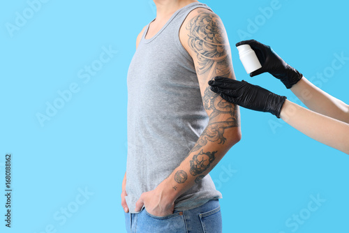 Tattoo master applying crea...