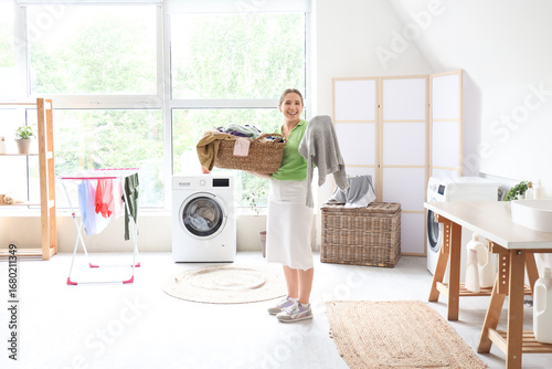 Young woman holding laundry...