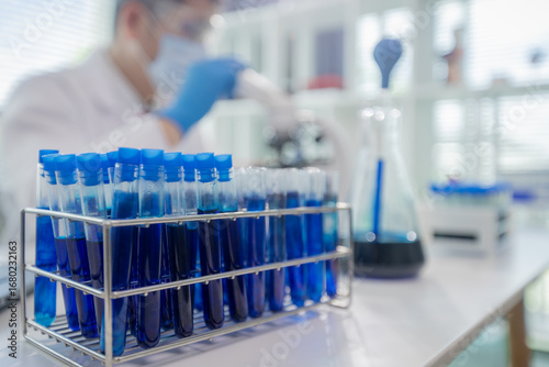 Scientists collaborating in laboratory, analyzing samples under microscope, conducting medical research and experiments for biotechnology, healthcare innovation, and scientific discovery.
