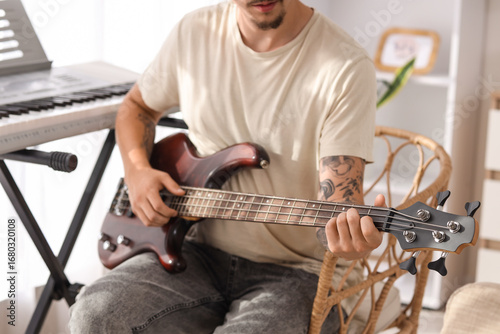 Young man playing electric ...