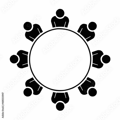 Eight people seated around a circular table, engaged in a meeting or discussion.