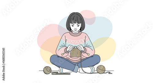 A young female artist knitting a scarf in a cozy setting while seated on the floor