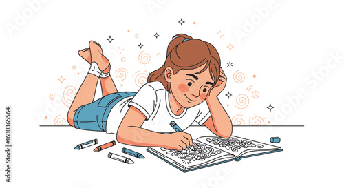 A young girl coloring in a book while lying on the floor, enjoying her free time