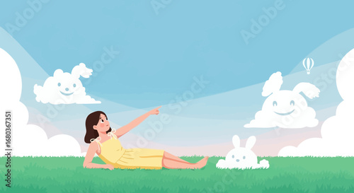 A young woman is lying on the grass looking at sky full of clouds and bunny shapes