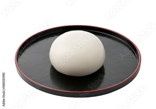 Round, white, steamed bun sits on a black lacquered tray, showcasing simple elegance.