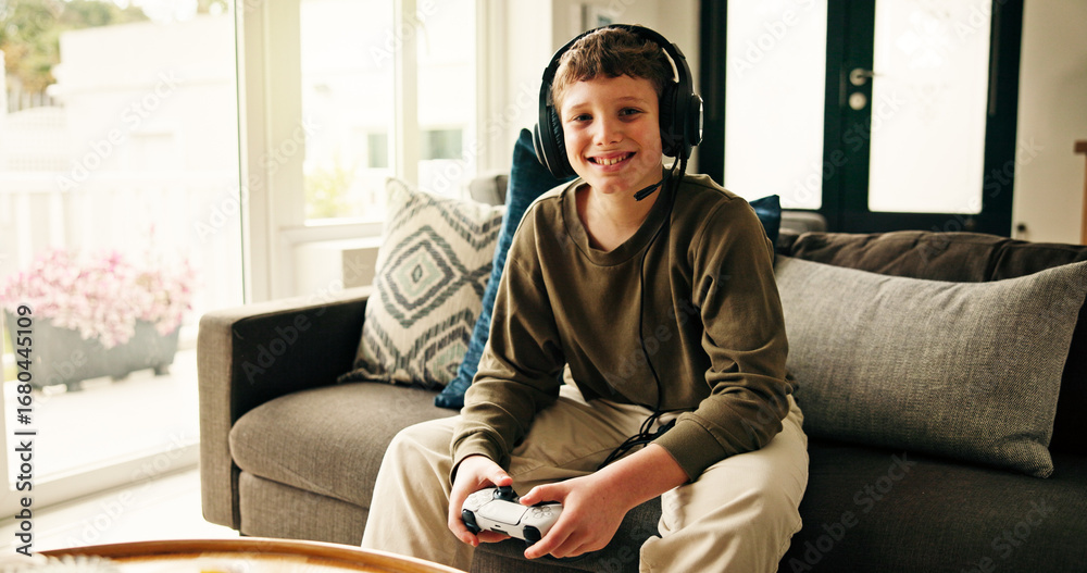 Fototapeta premium Portrait, video game and boy with controller, kid and entertainment with challenge. Home, headphones and child on sofa, online contest or sound with esports, click or smile with hobby or subscription