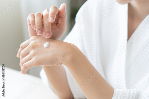 Принти на полотні Health care, beauty smile pretty asian young woman in bathrobe, towel after shower bath at home, finger applying moisturizer on her back hand