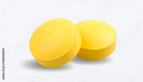 Two bright yellow pills on white