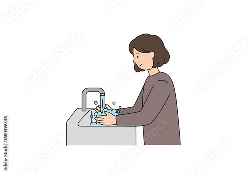 A woman washes her hands at a light gray sink under a silver faucet