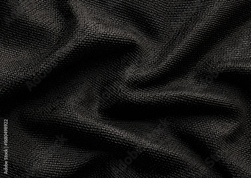 Close-up view of dark, textured fabric with draped folds