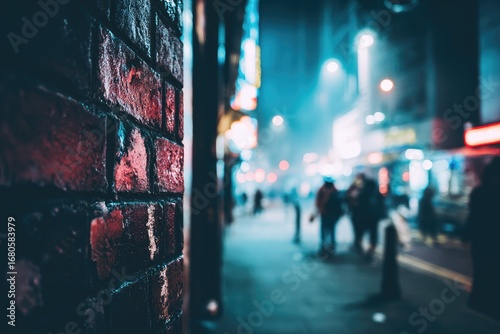 Fototapeta Naklejka Na Ścianę i Meble -  Night city street, brick wall in focus, blurry people