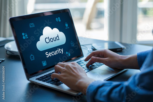 Person typing on laptop screen displaying cloud security icons and text hands keyboard
