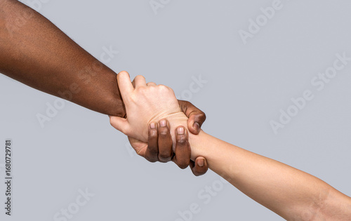 Photos Interracial forearm shake, helping , humanity and brotherhood concept, helping hands, rescue gesture