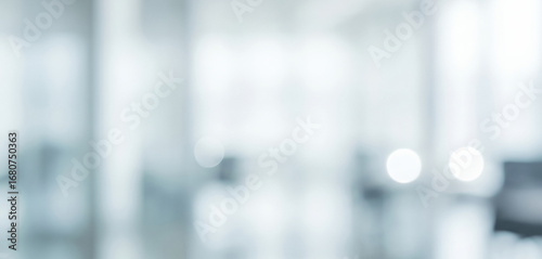 Blurred view of a bright interior space with white and light blue tones, giving a refreshing modern vibe filled with openness, elegance, and calm atmosphere.