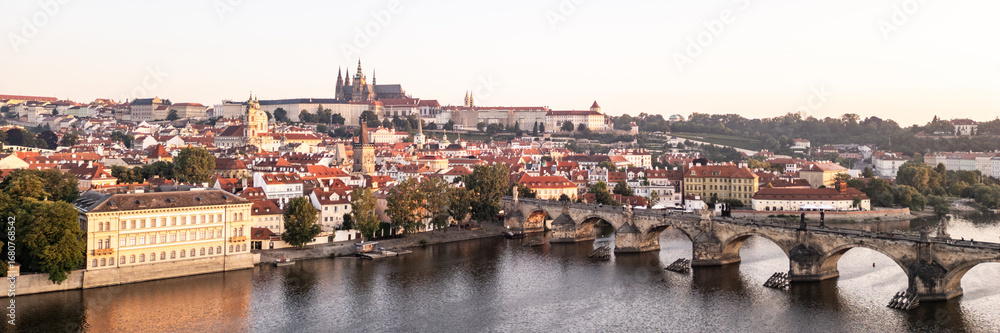 Fototapeta premium A breathtaking view of Prague at sunrise, showcasing the vibrant colors of dawn illuminating the medieval architecture.
