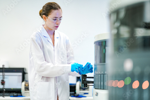 Cuadro en lienzo A focused female pathologist assistant carefully loads tissue slides into an automated IHC stainer, ensuring precise preparation for cancer diagnostics and biomedical research in a modern lab