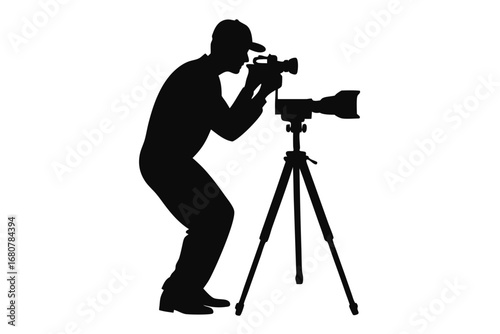 Silhouette of a Photographer with Cap Focusing on Camera on Tripod