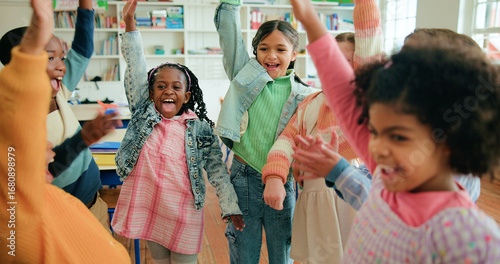 фотографія Children, excited or hands raised in celebration in classroom for recess, learning or end of school