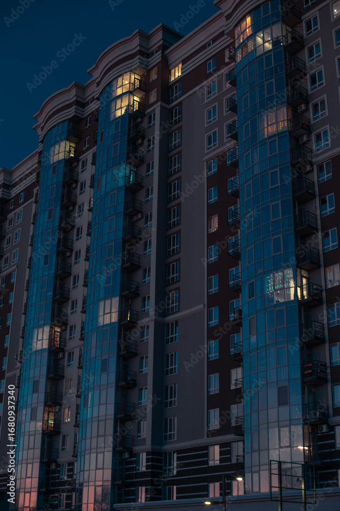 Obraz premium vertical city scape picture of glass skyscraper building long exposure night
