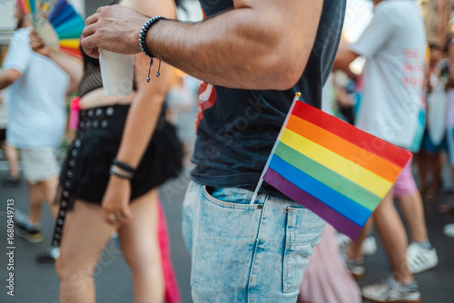Man showing rainbow flag at gay pride parade