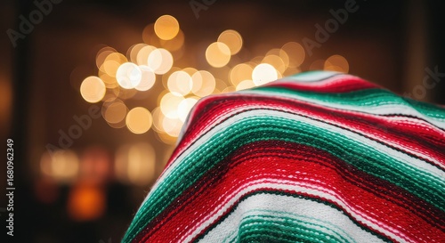 Cozy Mexican serape blanket draped over furniture with warm bokeh lights creating a festive, inviting atmosphere perfect for holidays or cultural events