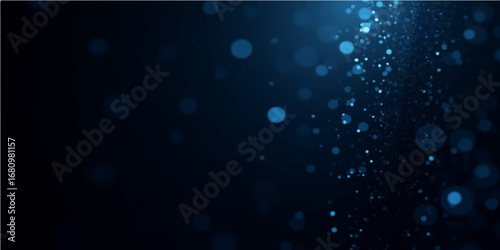 Blue light and shiny bokeh decorate a dark glass surface covered in water drops