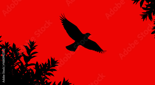Silhouette of a majestic bird of prey soaring through a vibrant fiery red sky with dark foliage framing the scene
