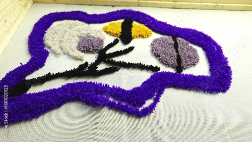 Needle of tufting gun weaving colorful carpet on canvas 