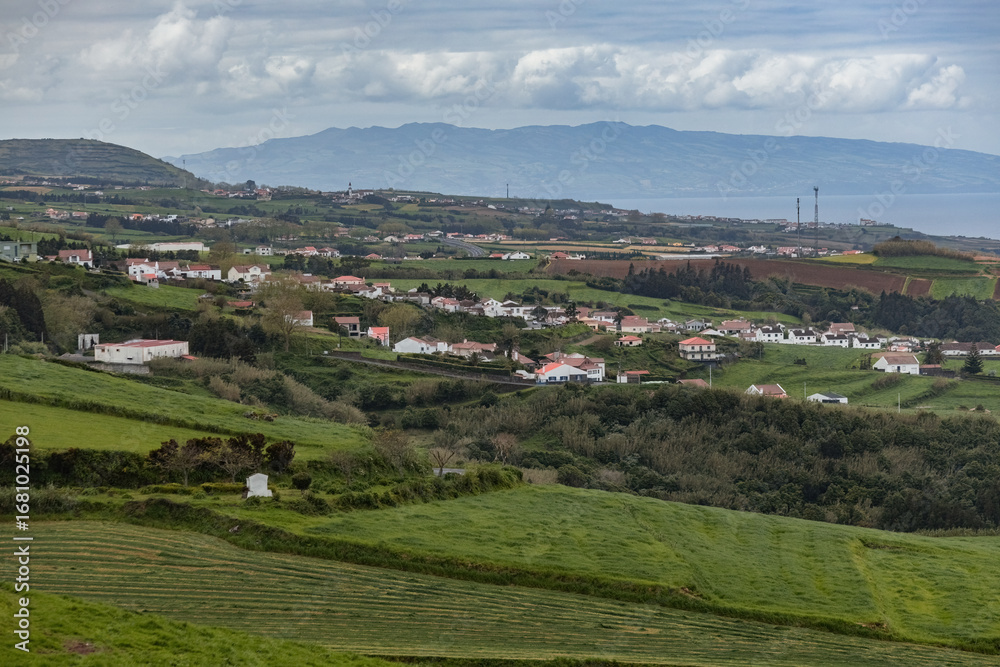 Obraz premium Green hills and traditional white houses in Azores islands Portugal