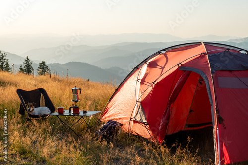 Remote mountain camping experience showcasing scenic horizon layers, red tent in highland meadow, tranquil nature mood, perfect visual for outdoor sports brands, hiking blogs, lifestyle content