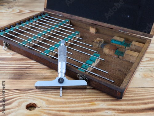 Cuadro en lienzo A set of vintage depth micrometers is displayed in an open wooden case on a rustic wooden table