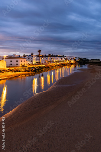 Die Stadt Conil de la Frontera und der Fluss Rio Salado in der Provinz Cadiz in Andalusien in Spanien bei Sonnenuntergang
