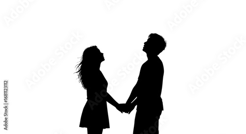 Romantic silhouette of a couple holding hands looking upwards together against a bright white sky