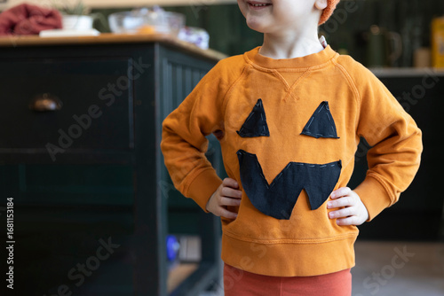 A little boy wearing a homemade pumpkin halloween costume