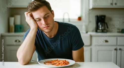 Tired young man, pasta, unappetizing meal