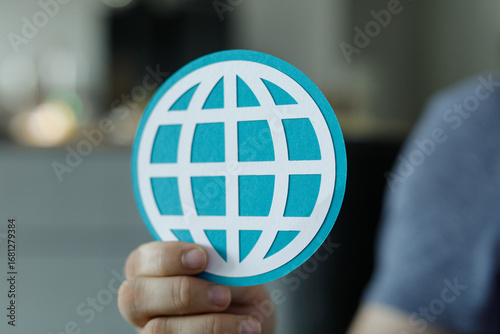 Hand holding a teal paper c...