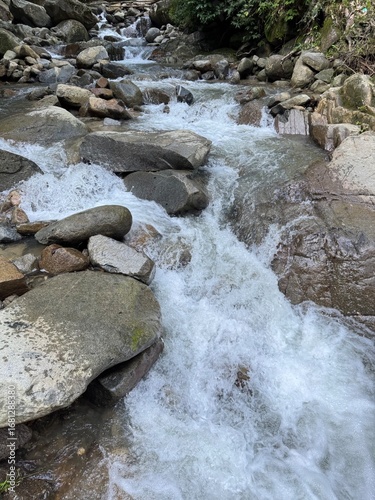Konstfotografi Vibrant mountain stream cascades over smooth rocks, creating a refreshing natura