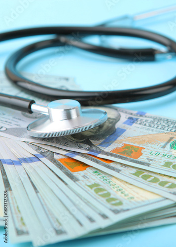 Medical stethoscope and money on a colored background top view close-up. Vertical photo format