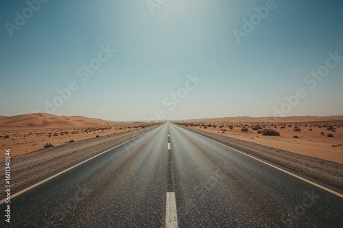 Desert highway stretching through vast sandy dunes, symbolizing liberation and adventure.