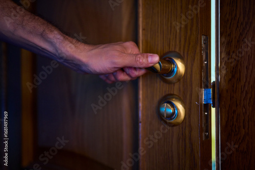 A hand is positioned on the door knob, fully prepared to open the entrance with ease