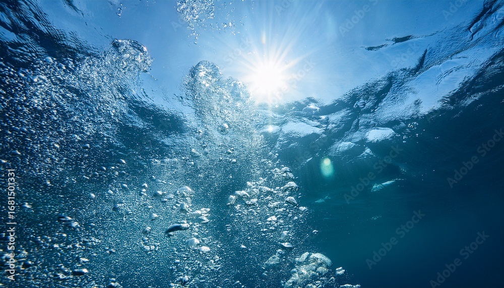 Fototapeta premium bubbles flowing under water with sun shining above; free space for text