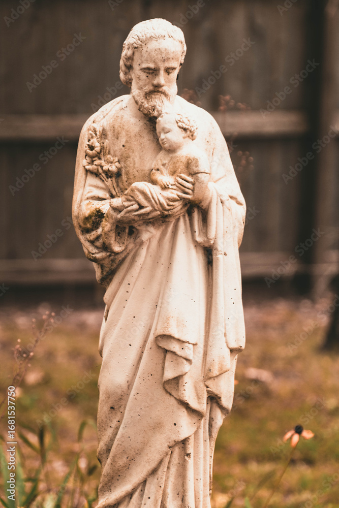 Obraz premium Saint Joseph Holding Baby Jesus Statue in Yard