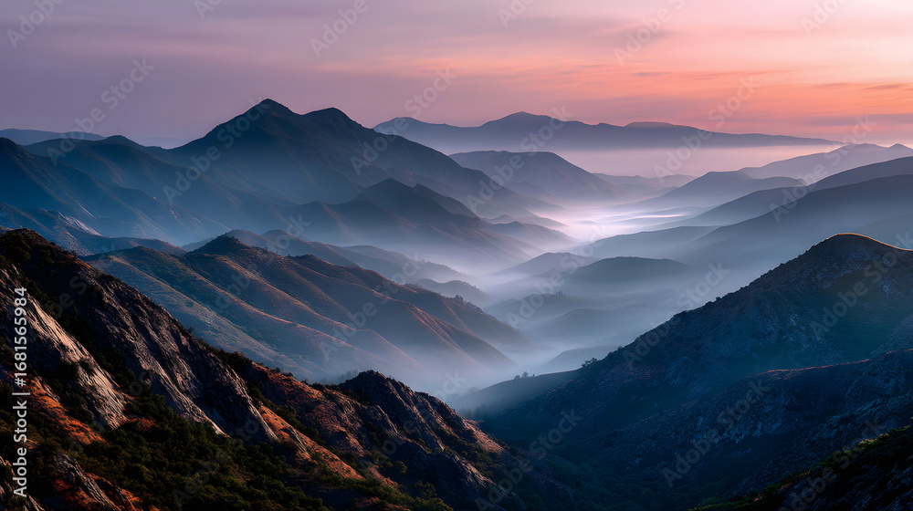 Fototapeta premium Colorful mountain range fading into a foggy valley a golden hour.