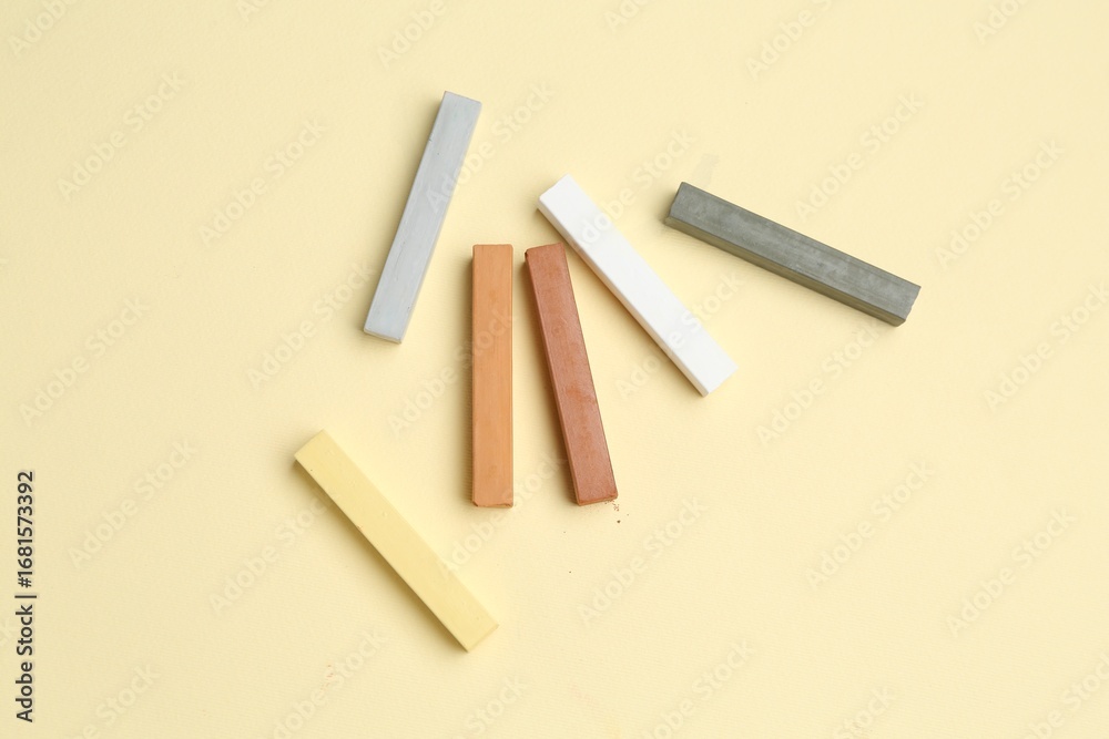Obraz premium Many colorful chalk pastels on beige background, flat lay