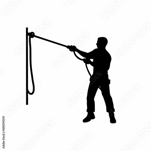 Silhouette of cable installer using pulley system to drag thick wire