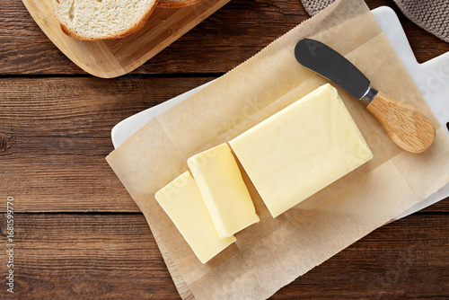 Sliced pieces of butter on a cutting board, wooden background. Piece of butter. Top view