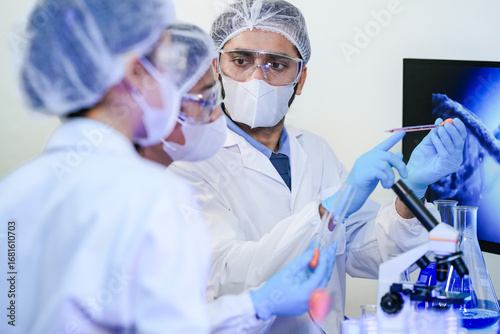 Fotografie scientists in protective masks and goggles work closely together in a research lab