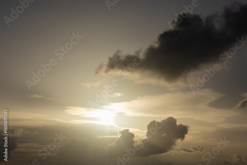 Image of dramatic cloudscape gray dark fluffy clouds bright sun rays at sunset