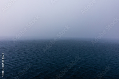 Gloomy ocean horizon raining on the open vast western Caribbean Sea , Image taken from deck of cruise ship.
